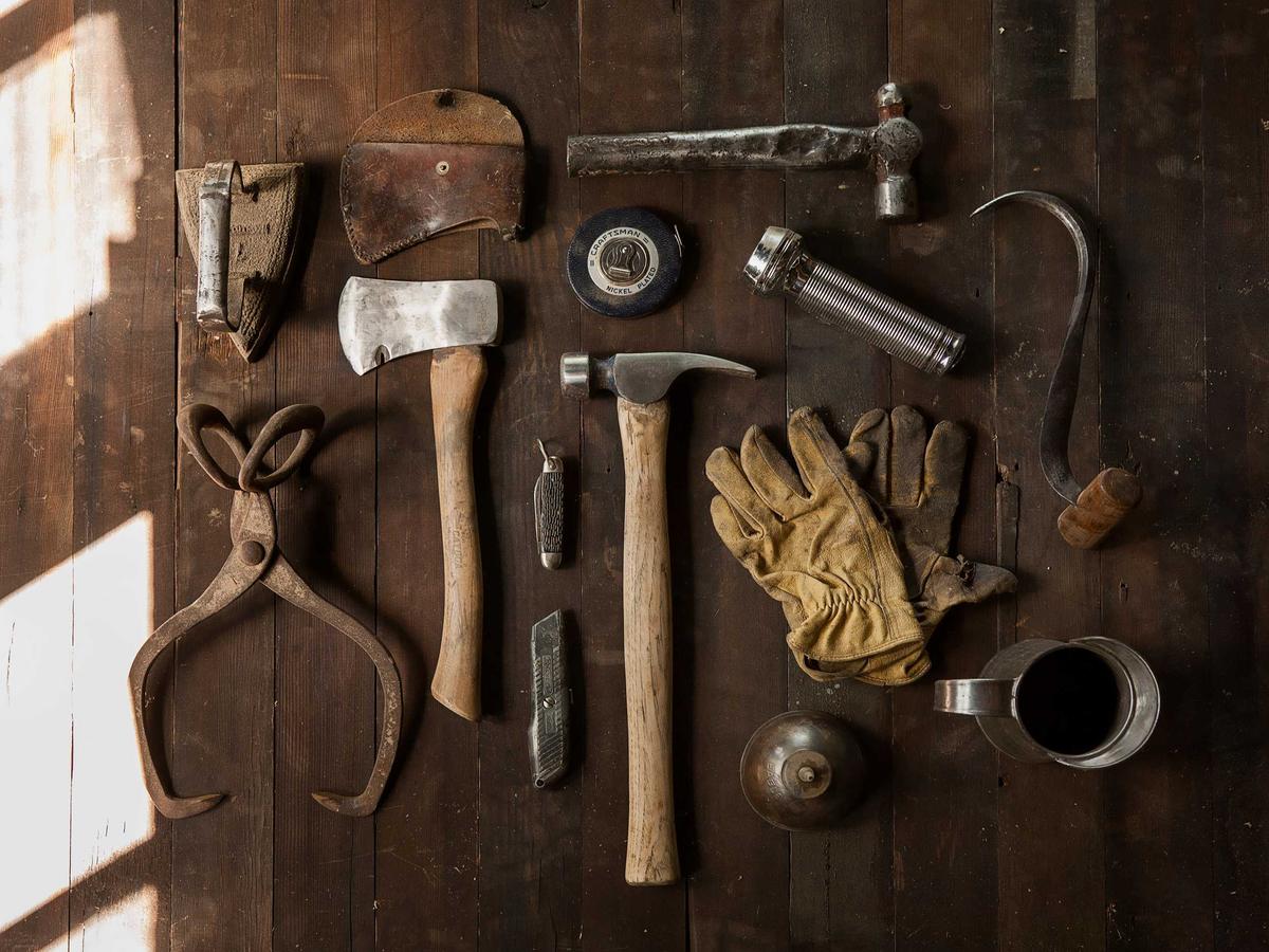 Hand tools laid out on dark wood